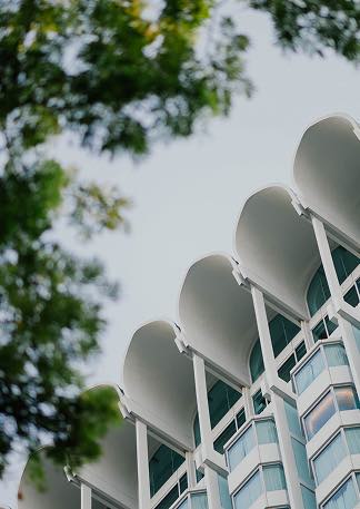 Bâtiment moderne avec arches blanches et fenêtres en verre sous ciel clair